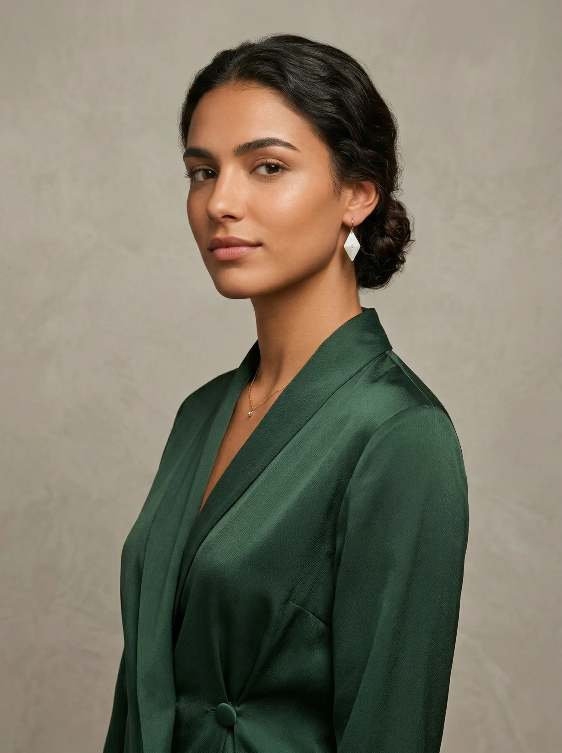 Please provide me with a hyperrealistic advertising photograph created by a top-tier advertising agency, featuring good lighting of a young, beautiful, and well-dressed Spanish model wearing these small earrings—28 mm tall and 14 mm wide—where the proportions of the earrings and her face are accurate, given that the earrings are small. The image should be a professional mid-shot editorial shot with an elegant, neutral background.